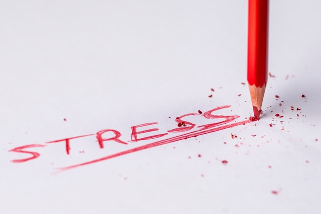 cuvântul "stres" scris pe engleză cu un creion roșu