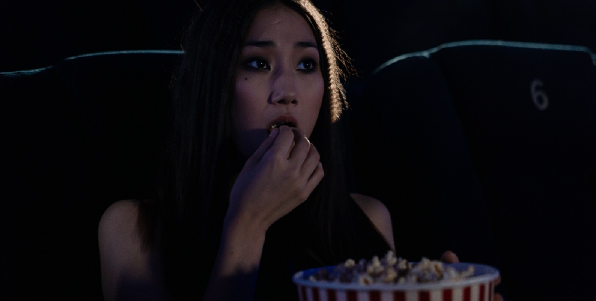 fată ce mănăncă popcorn la cinema