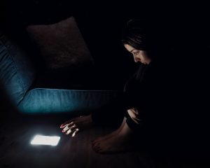 o fată ce stă noaptea lângă telefonul său